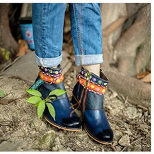 Nahaufnahme von stilvollen Vintage Lederstiefeletten mit bunten Ethno-Stickereien.