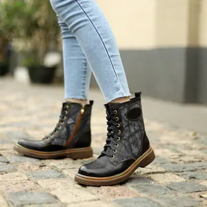 Bottes gothiques à lacets avec coutures colorées sur des pavés en extérieur