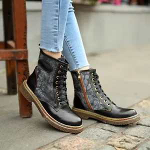 Gros plan de bottines noires style gothique biker avec coutures décoratives colorées