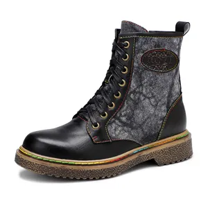 Gros plan de bottes de motard gothiques avec coutures colorées et empiècements en jean
