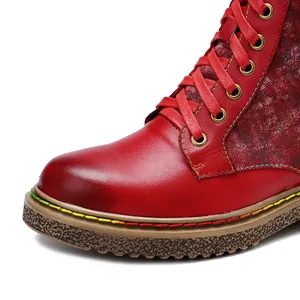 Gros plan de bottines motardes gothiques rouges avec surpiqûres arc-en-ciel et lacets