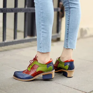 Close-up of retro patchwork Brogue shoes with floral perforations and chunky heels.