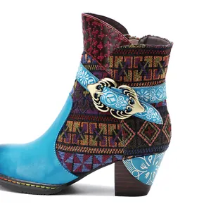 Dettaglio di stivaletti boho colorati con motivi etnici e fibbia metallica decorativa.