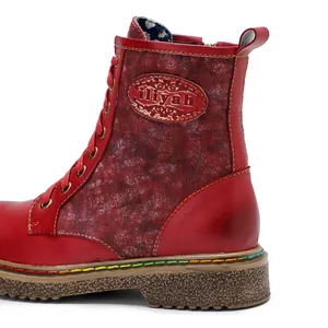 Détail d'une bottine rétro rouge à lacets avec empiècement floral et coutures colorées.