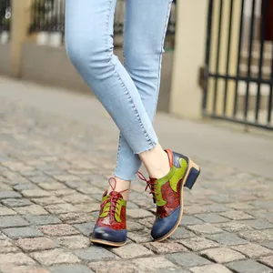 Detailed view of colorful retro ethnic Brogue patchwork shoes on a model wearing jeans