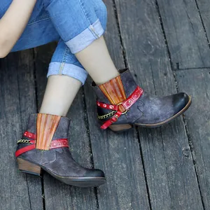 Vue détaillée de bottines ethniques faites main avec broderies et détails de chaîne en métal