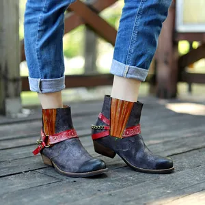 Bottines de cow-boy artisanales vieillies pour femmes sur un pont en bois rustique