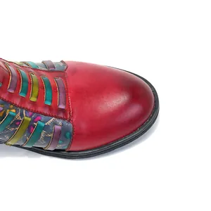 Gros plan de bottines vintage en cuir rouge avec détails tissés colorés style folk