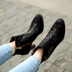 Detail view of vintage black lace ankle boots with colorful stitching and block heel