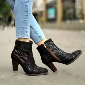 Detailed side view of black lace ankle boots with chunky heels and vintage stitching