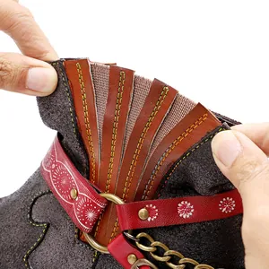 Détail d'une bottine en cuir givré fait main avec sangle rouge et coutures déco