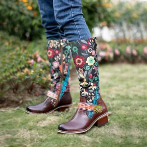 Close-up detail of retro floral ethnic style knee-high boots worn by a model in a garden
