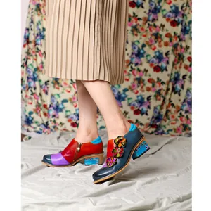 Close-up of retro color-block Brogue shoes with 3D floral accents and block heel.