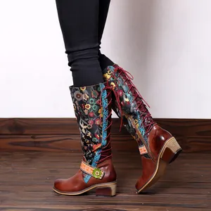 Detailed view of retro ethnic floral patterns and red laces on leather knee-high boots