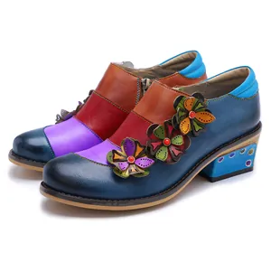 Close-up of retro color-block leather shoes with 3D floral accents and a block heel