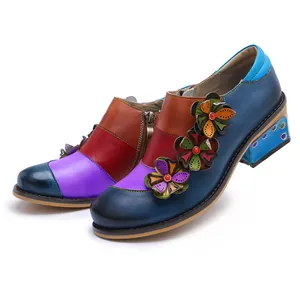 Detailed view of colorful retro patchwork leather shoes with floral appliques and chunky heels