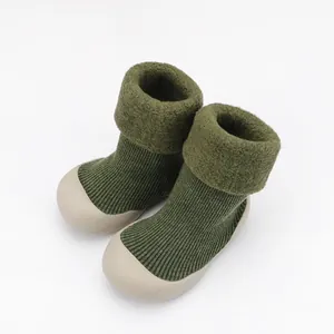 Dettaglio scarpe neonato in maglia spessa con risvolto in peluche e suola morbida