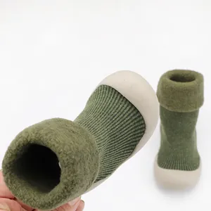 Primo piano di scarpe a calzino invernali per neonati con collo in morbido peluche.