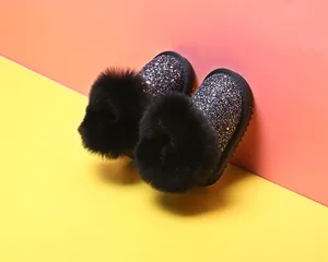 Detailansicht funkelnde Mädchen Schneestiefel mit übergroßen schwarzen Pelzpompons