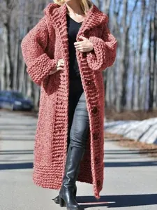 Detailed view of a thick terracotta chunky knit hooded long cardigan on a model
