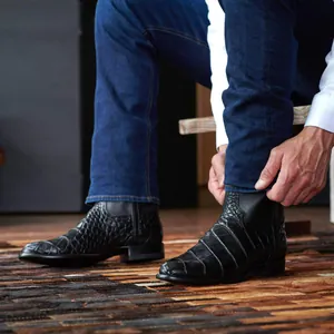 Gros plan de bottines western noires pour hommes avec texture crocodile et cuir de qualité