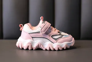 Gedetailleerd zijaanzicht van roze en witte meisjessneakers met zachte zolen en klittenband.