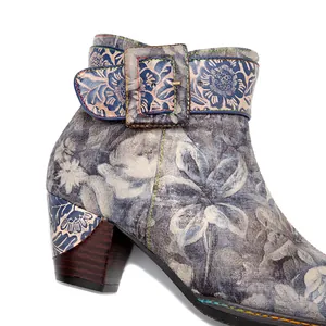 Close-up view of vintage floral leather texture and buckle detail on block heel boot