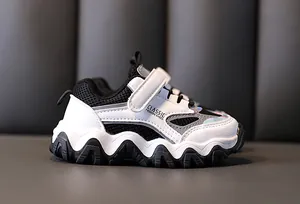 Zijaanzicht detail van wit-zwarte kinder sport sneakers met mesh en klittenband