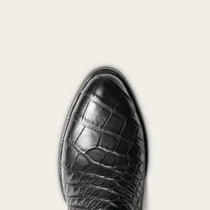 Vue macro détaillée de la texture crocodile noire sur des bottes de cowboy western vintage