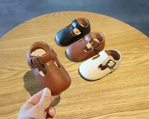 Weiche Baby Leder-T-Steg-Schuhe in verschiedenen Farben auf Holztisch
