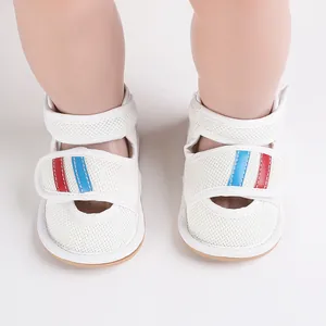 Close-up of white breathable mesh baby walker shoes with red and blue striped Velcro