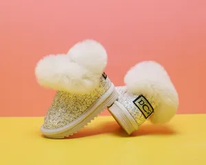 Detailansicht der glitzernden silbernen Baby-Schneestiefel mit flauschigem weißem Fellbesatz