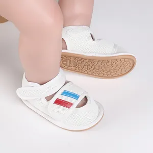 Detailed view of white mesh baby walking shoes with blue and red stripe accents