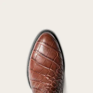Gros plan macro sur la texture crocodile marron des bottes de cowboy pour hommes