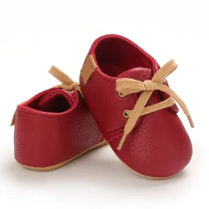 Close-up of red pebbled leather baby walking shoes with soft soles