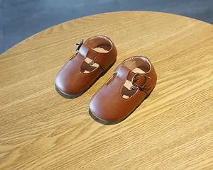 Detailansicht klassischer brauner T-Steg-Lauflernschuhe aus Leder mit weicher Sohle.