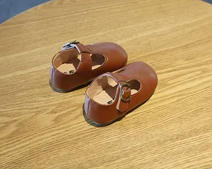 Klassische braune Leder-Lauflernschuhe für Kleinkinder mit weichen Sohlen.