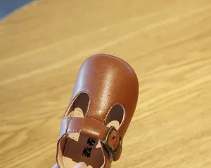 Detailaufnahme eines braunen Lauflernschuhs für Babys aus Leder mit T-Steg-Schnalle