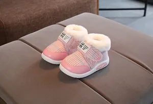 Detail view of pink plaid baby snow boots with warm white fuzzy lining and velcro strap