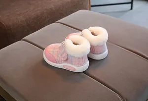 Close-up view of pink plaid toddler snow boots featuring cozy white faux fur trim detail