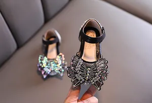 Detail van zwarte prinsessenschoenen voor meisjes met kleurrijke vlinderstrik