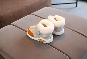 Close-up detail of plaid baby winter boots featuring a soft and warm white faux fur collar