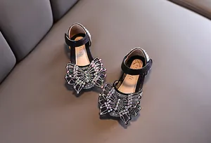 Detailweergave van zwarte prinsessenschoenen voor meisjes met strass-vlinder