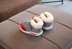 Close-up of baby plaid snow boots featuring warm faux fur lining and durable white soles
