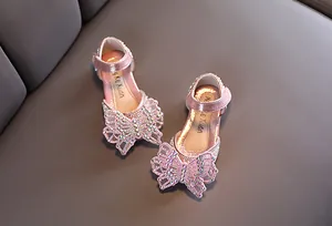 Detailopname van elegante roze meisjes prinsessenschoenen met fonkelende strass vlinder details