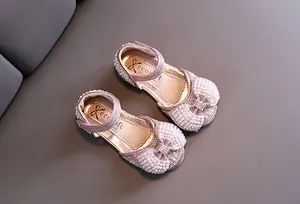 Zapatos de princesa rosas para niñas con pedrería brillante, perlas y un lazo grande.
