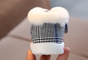 Close-up view of a baby walker shoe heel featuring blue checkered fabric and white faux fur lining