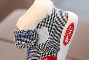 Detailed view of baby winter boots featuring warm white faux fur lining and blue plaid canvas.