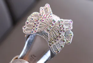 Detailweergave van het fonkelende vlinderornament met strass op prinsessenschoenen voor meisjes