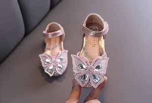 Vue détaillée de la chaussure de princesse rose avec grand papillon en cristal.
